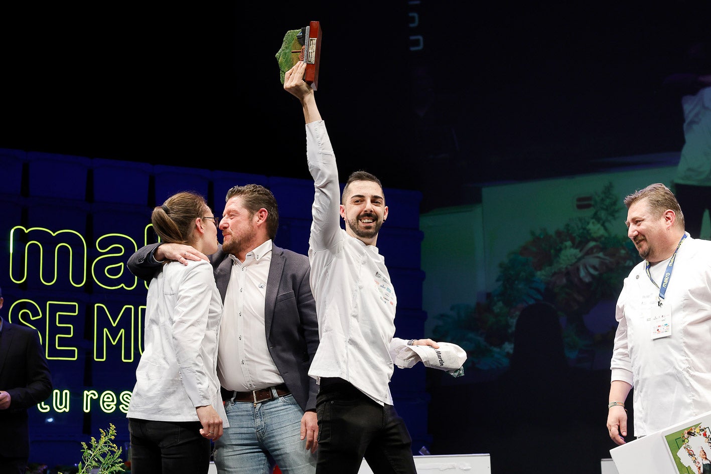 Abel Castaño alza el brazo con el galardón al mejor postre de hojaldre, en el escenario. 