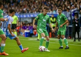 Íñigo Vicente controla la pelota en La Rosaleda mientras Larrubia, del Málaga, se aproxima al extremo racinguista.