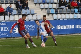 Chus Ruiz controla el balón ante dos rivales del Ávila.