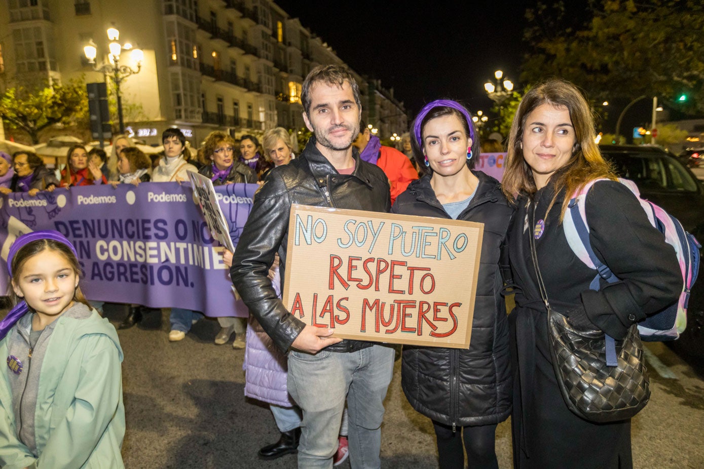 Tres amigos con una pancarta contra la prostitución.