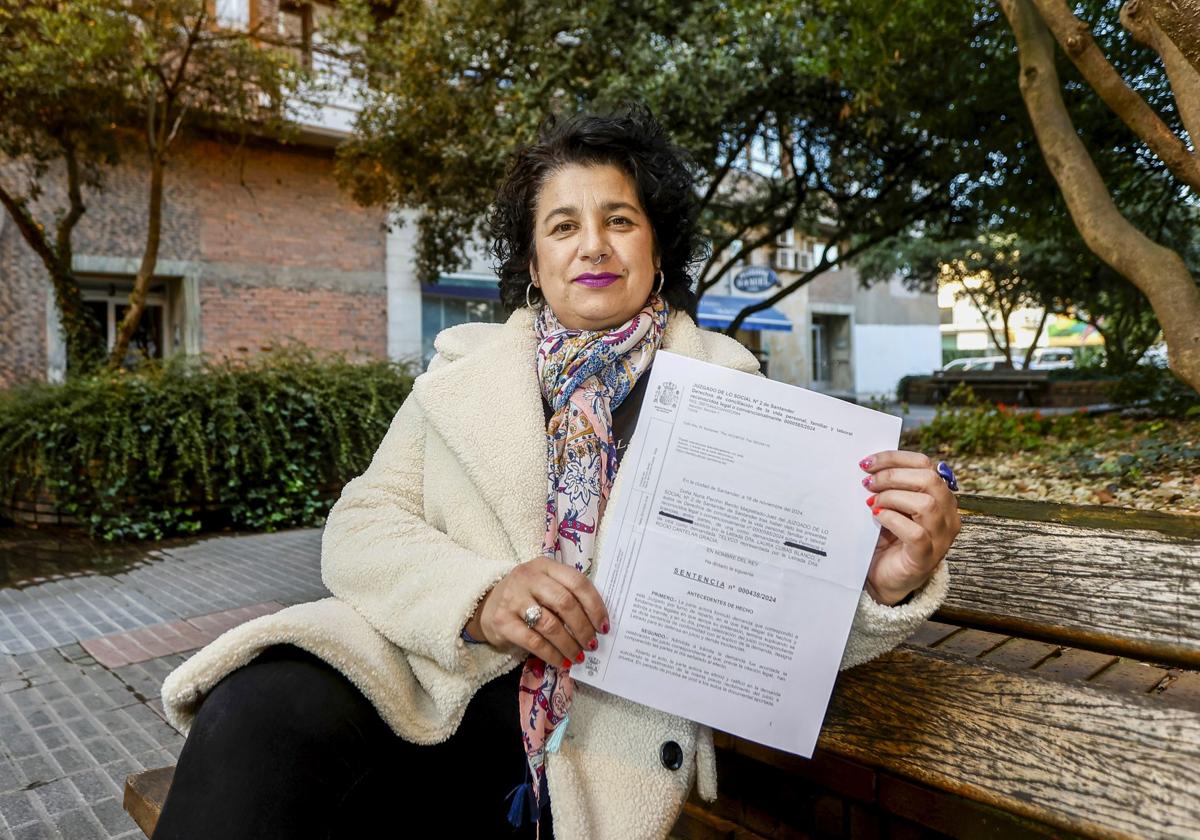 Gloria María Lobeto Ruiz posa con la sentencia en la que se reconoce su derecho al cambio de horario para el cuidado de su nieta, en Torrelavega.