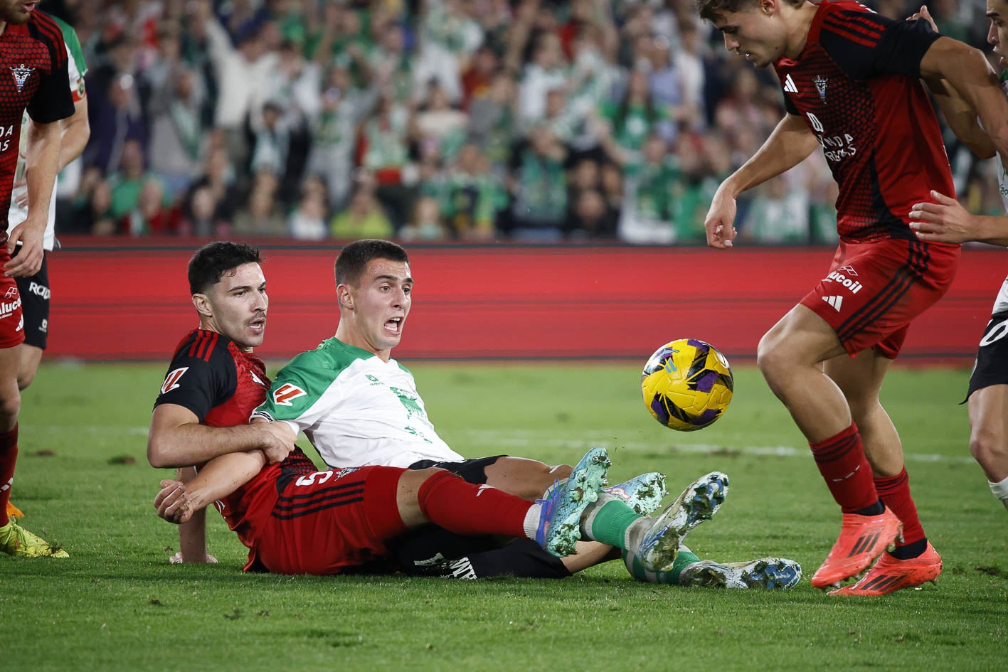 Karrikaburu, en el suelo, pugna por un balón con Tachi. 