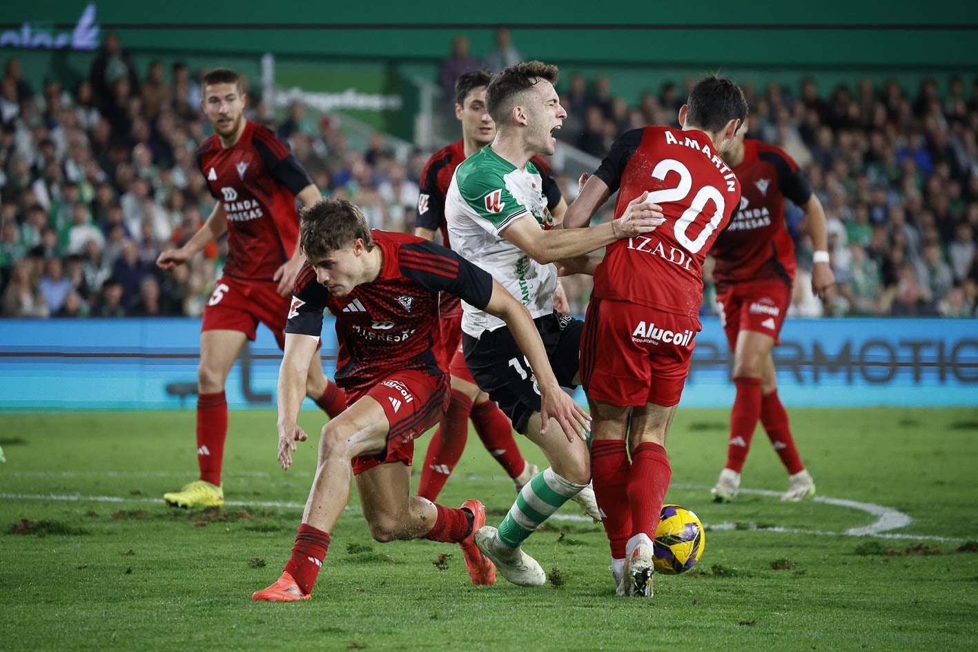 Íñigo Vicente cae en el área, rodeado de jugadores del Mirandés. 