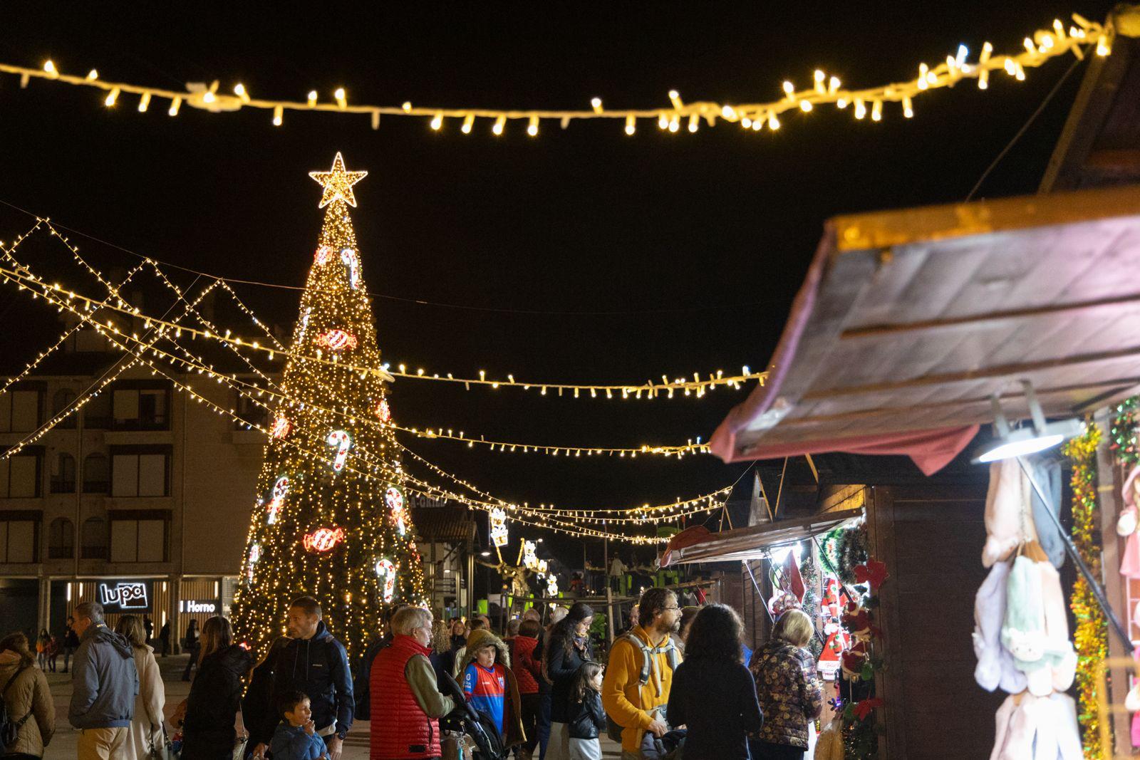 Mercado navideño en la plaza con un árbol gigante. 