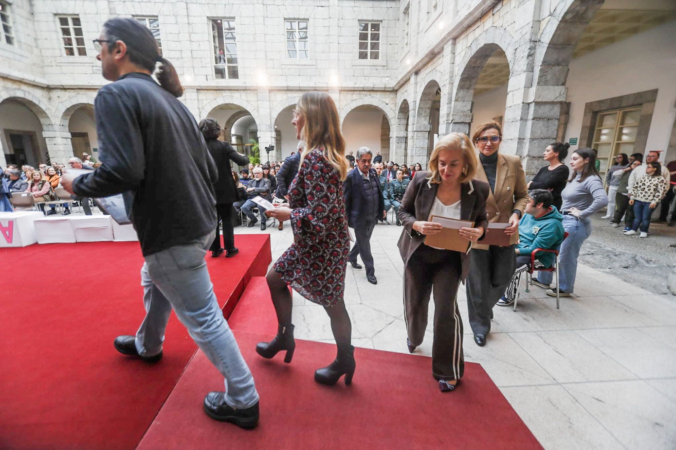 La delegada del Gobierno, Eugenia Gómez de Diego; la presidenta del Parlamento, María José González Revuelta, y Miguel Ángel Revilla, al fondo, en un momento del acto. 