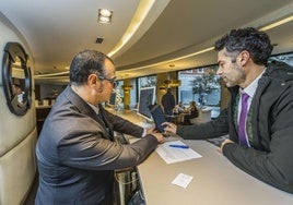 Un recepcionista formaliza el registro de datos personales de un cliente en el Hotel Bahía de Santander.