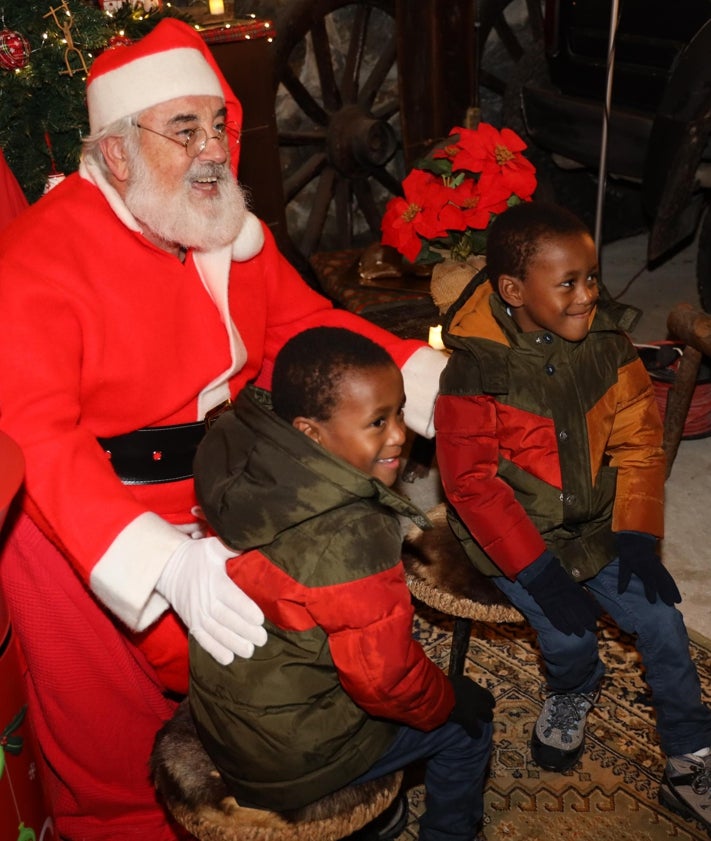 Imagen secundaria 2 - Actividades realizadas en el salón de la antigua Obra Pía, y dos hermanos se fotografían con Papa Noel después de entregar sus cartas