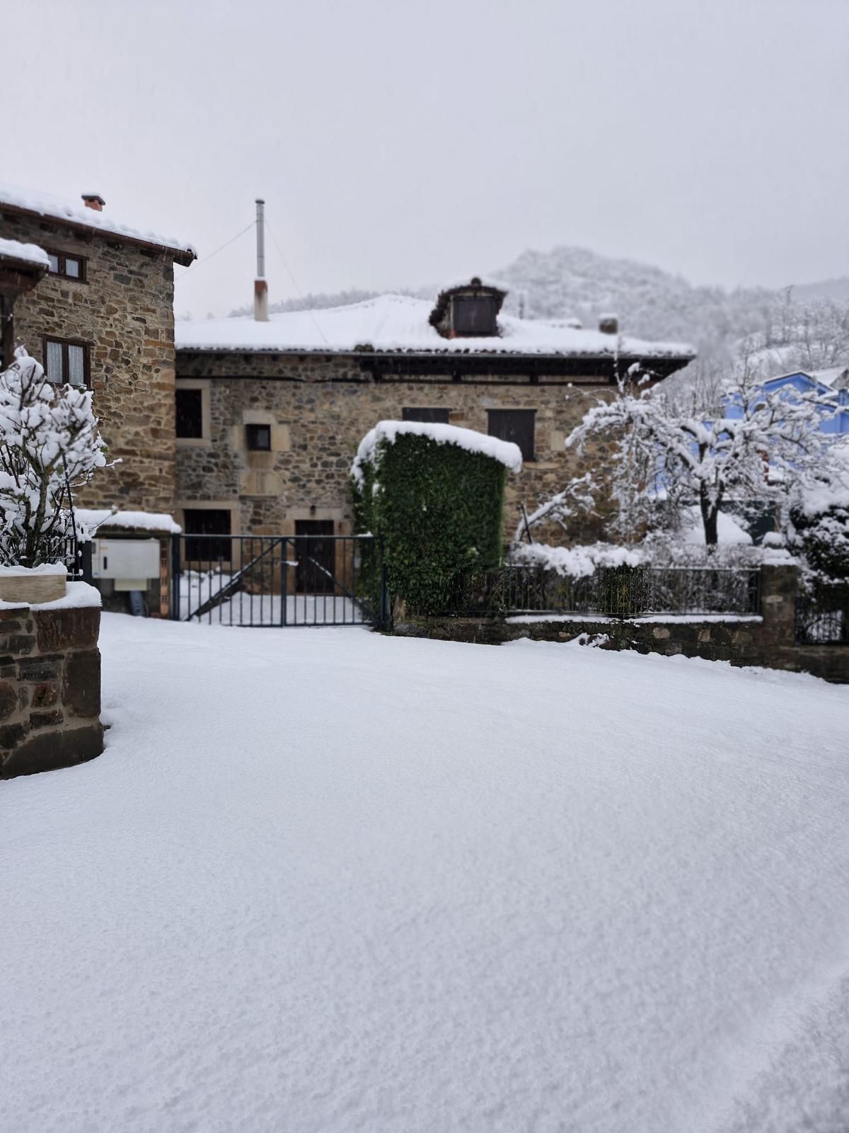 La nieve tapa por completo tejados y jardines en las casas de Espinama