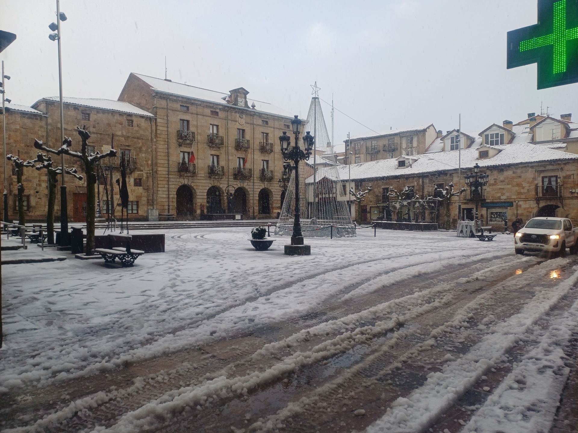 Los adornos navideños instalados en la plaza del Ayuntamiento de Reinosa, con la nieve animando el decorado