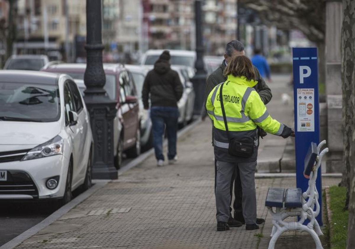 Controlador de la OLA revisa un parquímetro junto a un cliente.