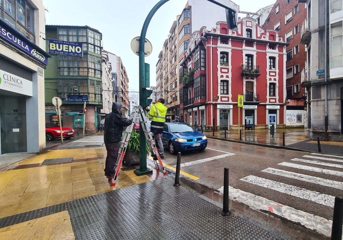 Operarios de la adjudicataria reparan uno de los semáforos de la calle José María Pereda, este martes a primera hora de la tarde, en Torrelavega.