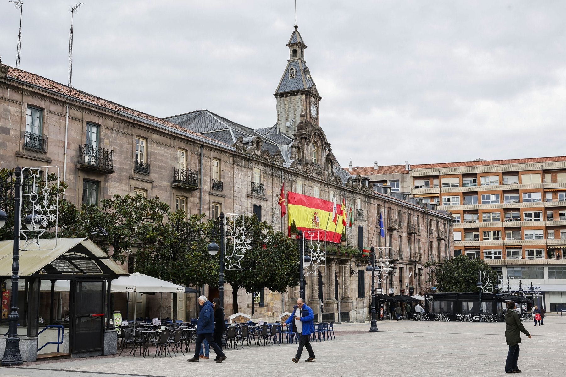 Vecinos caminan frente al Palacio municipal de Torrelavega, cerrado desde hace años, en el Bulevar Demetrio Herrero.