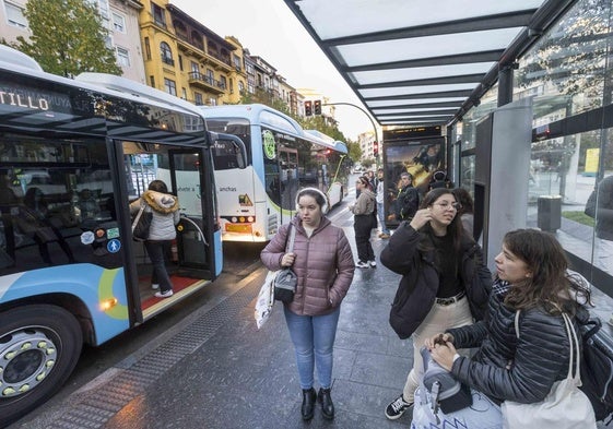 Varios usuarios del TUS esperan en la parada de la plaza del Ayuntamiento de Santander.