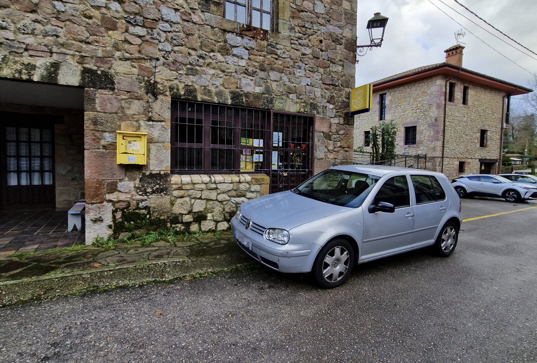 Un coche aparcado junto a la oficina de Correos de Santillana del Mar.