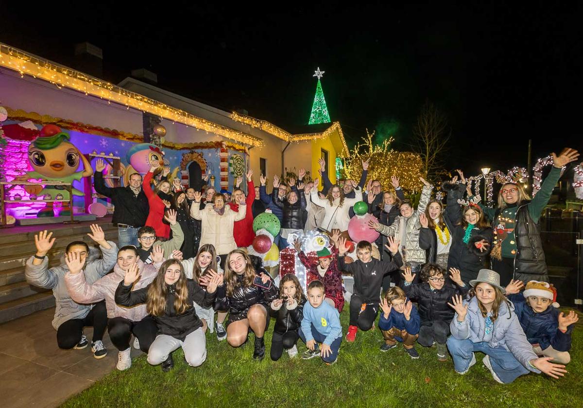 Los vecinos que han decorado el pueblo de Quijano posan en el jardín de una de las viviendas que ha tematizado la Navidad.