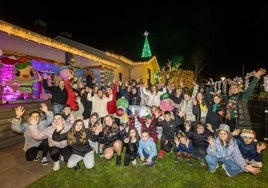 Los vecinos que han decorado el pueblo de Quijano posan en el jardín de una de las viviendas que ha tematizado la Navidad.