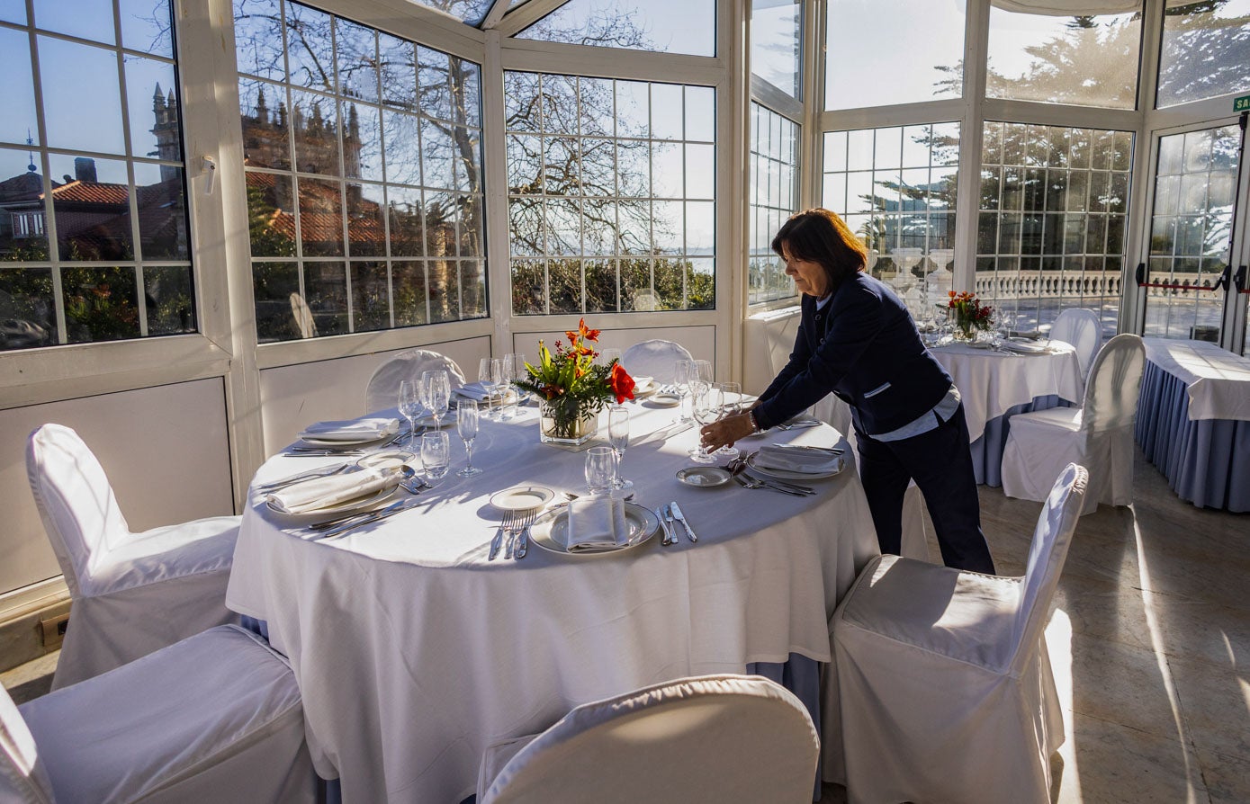 Una trabajadora del Hotel Real pone a punto una mesa del salón principal.