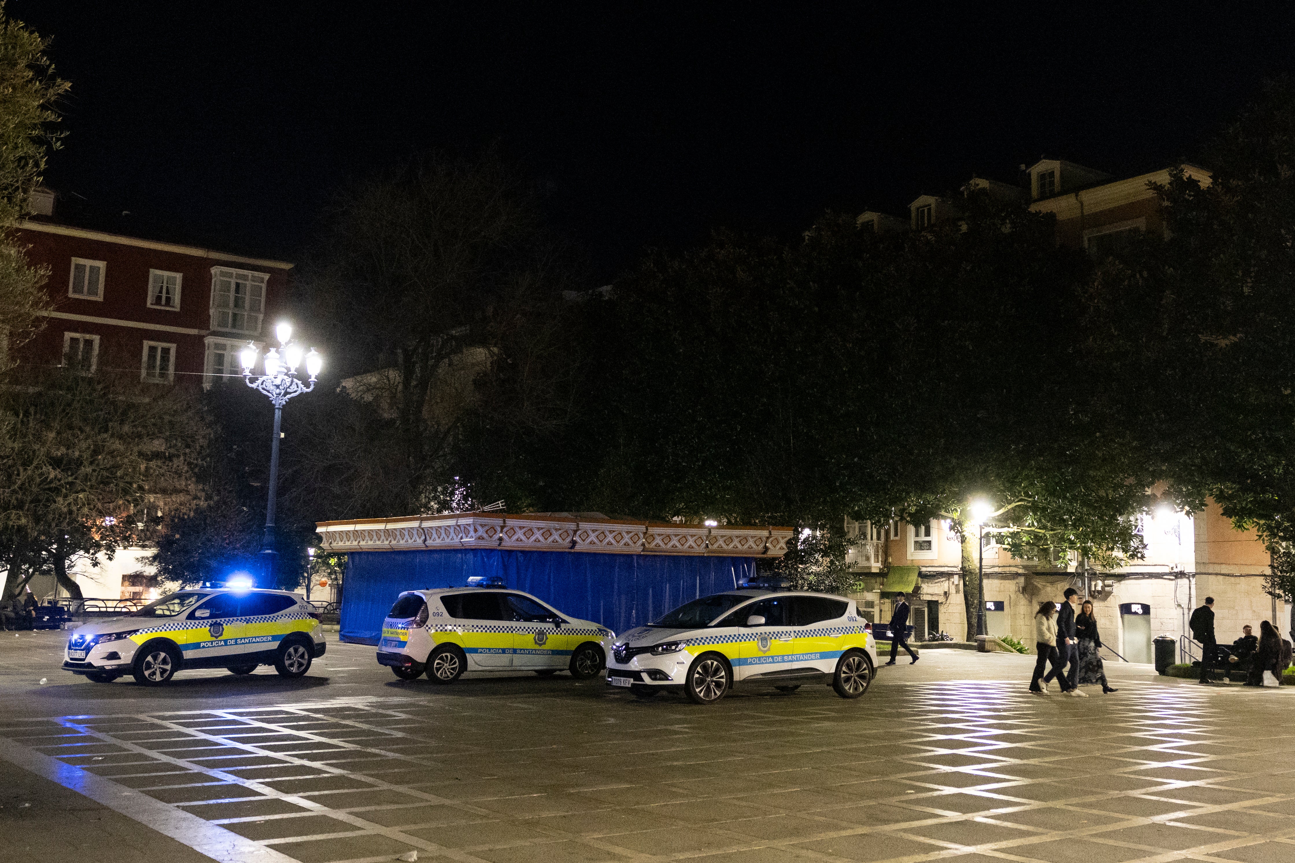 Coches de la Policía Local en la plaza de Pombo para disuadir a aquellos que se acercaban con bolsas de bebidas con intención de hacer botellón.