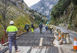 Obreros trabajan en la renovación de uno de los tramos con voladizo de la N-621, en el Desfiladero de la Hermida.