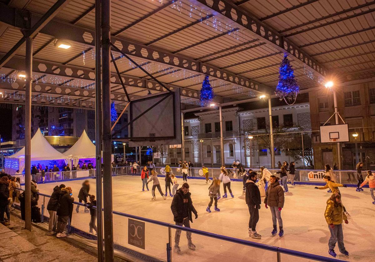 Vecinos patinan en la pista de hielo, ubicada en La Llama, esta Navidad, en Torrelavega.