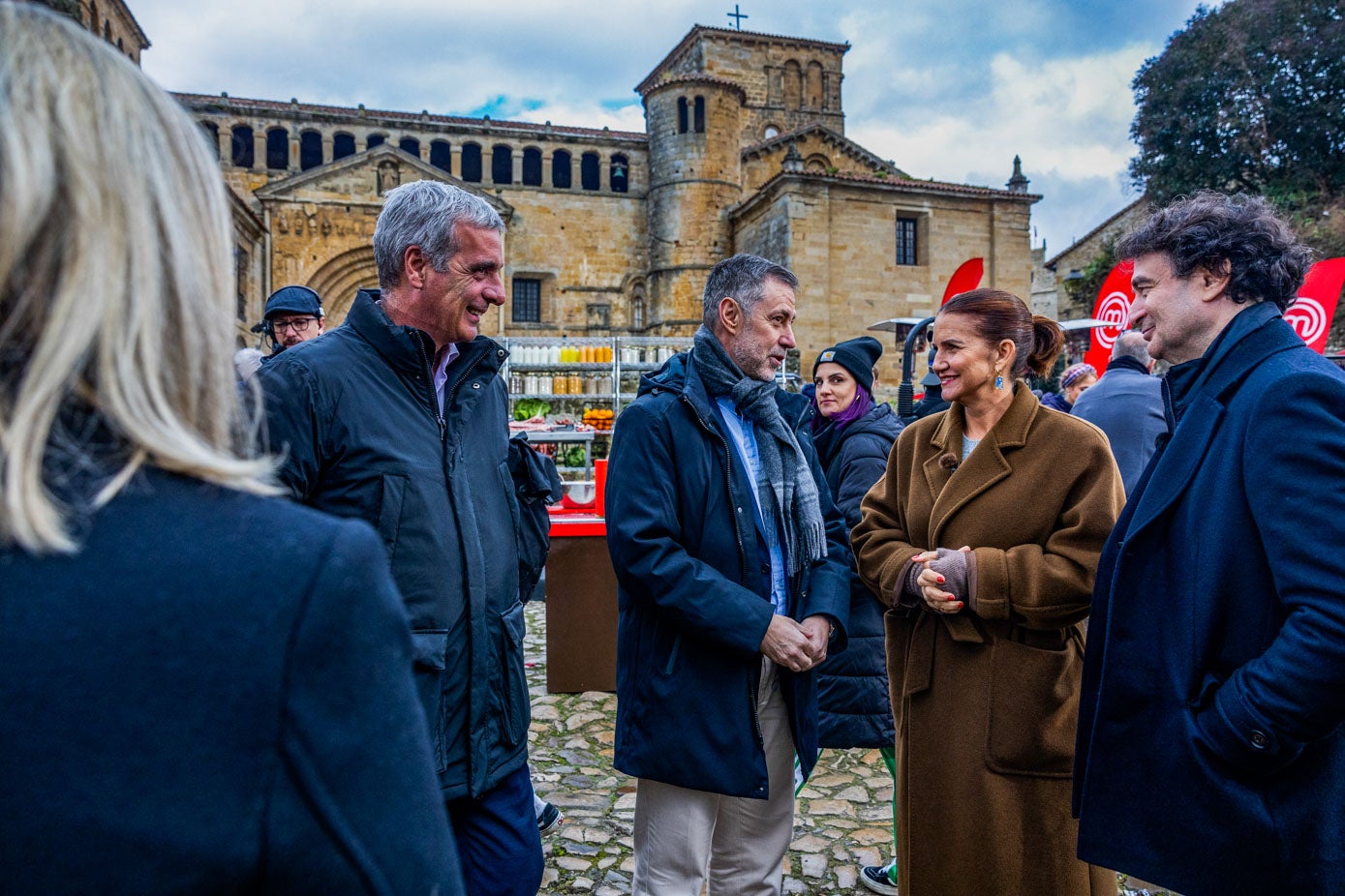 La alcaldesa de Santillana del Mar, Sara Izquierdo (de espaldas); el director general de Turismo, Gustavo Cubero y el consejero de Turismo, Luis Martínez Abad, charlan con Samantha Vallejo-Nájera y Pepe Rodríguez, populares miembros del jurado de MasterChef.