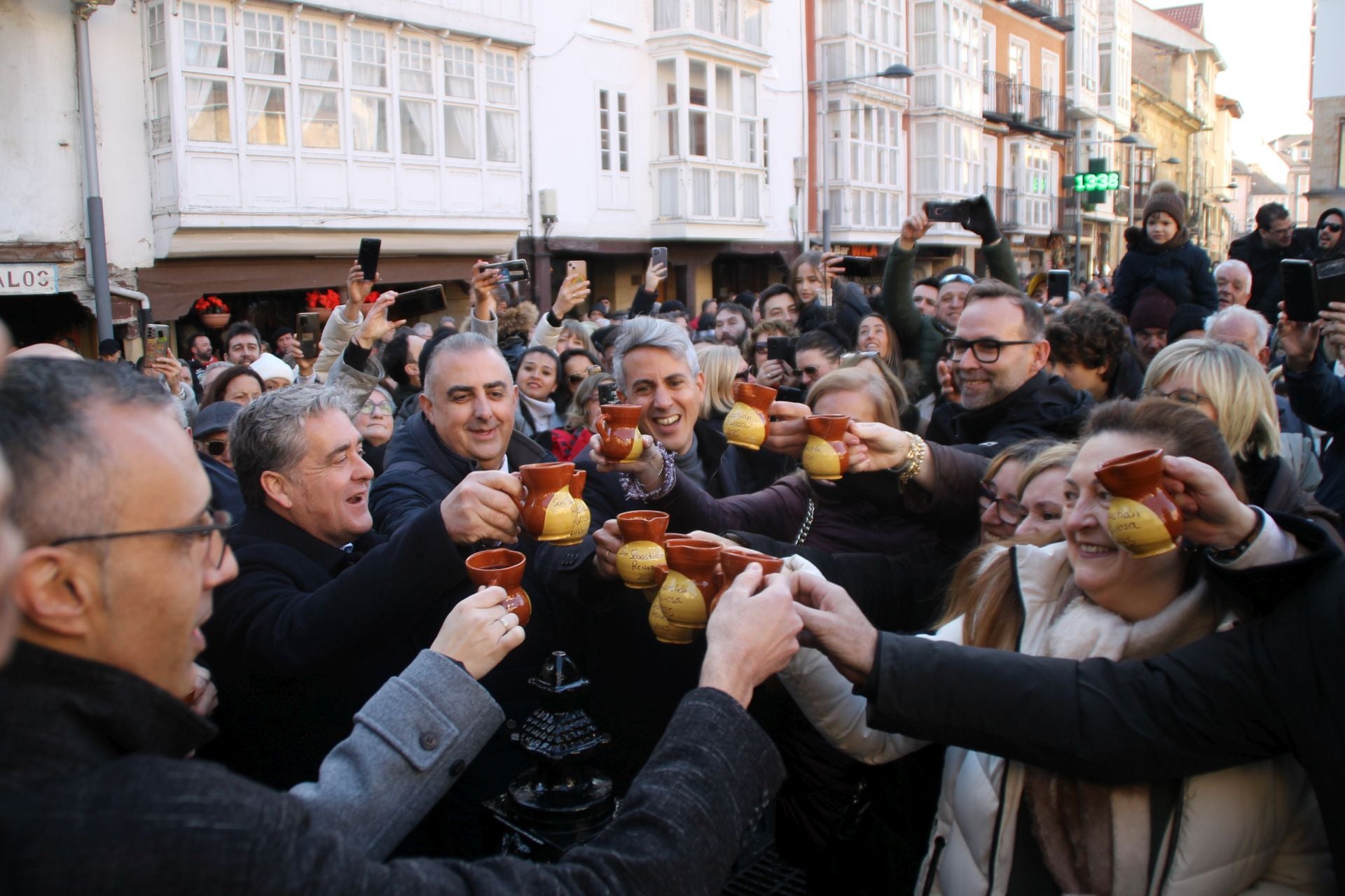 Autoridades y vecinos brindan con el vino que mana de la fuente.