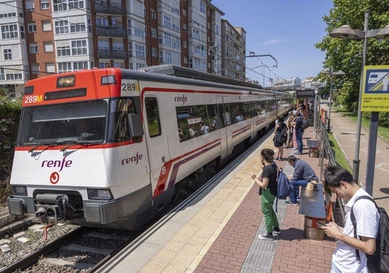 Los usuarios de las Cercanías esperan la llegada del tren en la estación de Muriedas.