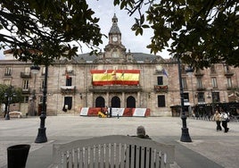 Vecinos caminan frente al Palacio municipal de Torrelavega.