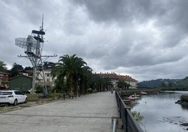 Algunos transeúntes caminan por el paseo de la ría de Limpias.