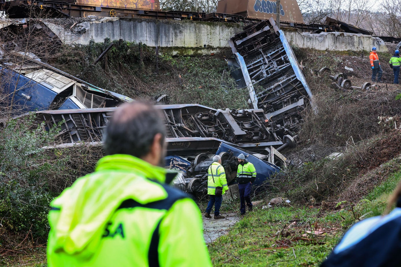 Dos técnicos, al fondo, observan el estado en la quedó la locomotora en la que iba el maquinista que resultó herido.