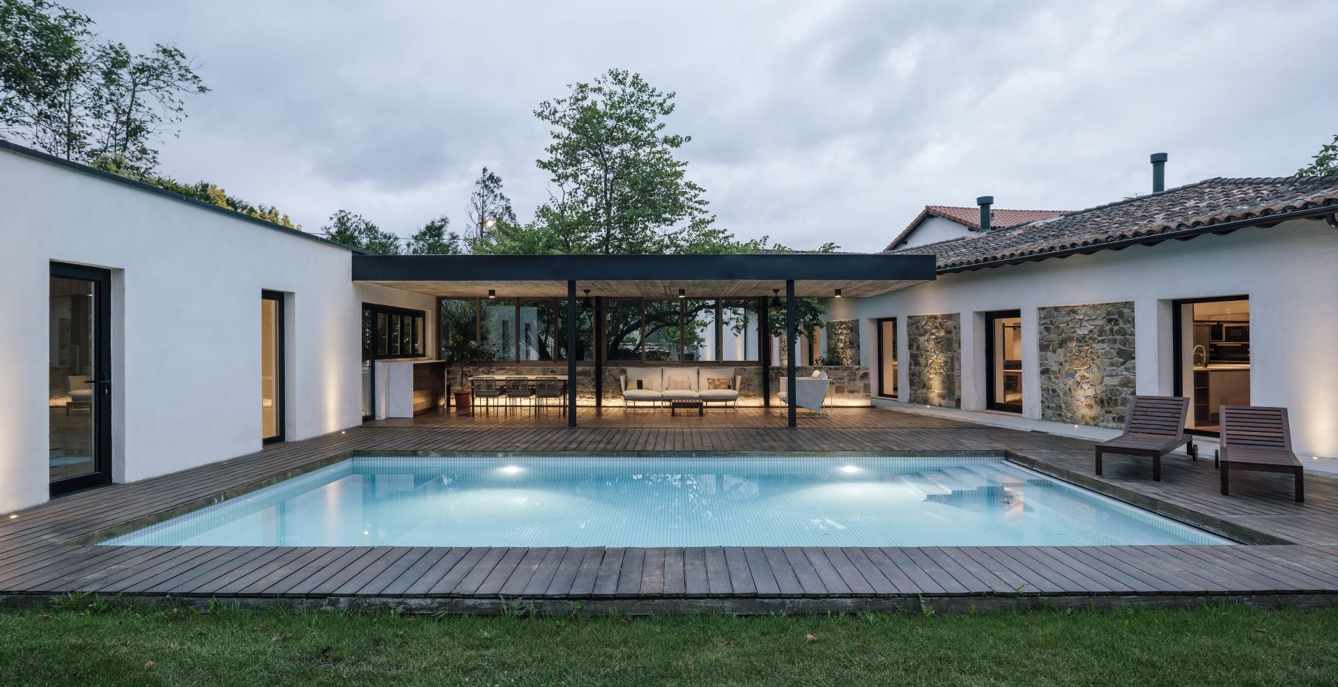 La piscina conecta la casa de invitados (a la izquierda) con la principal, que eran las antiguas caballerizas.