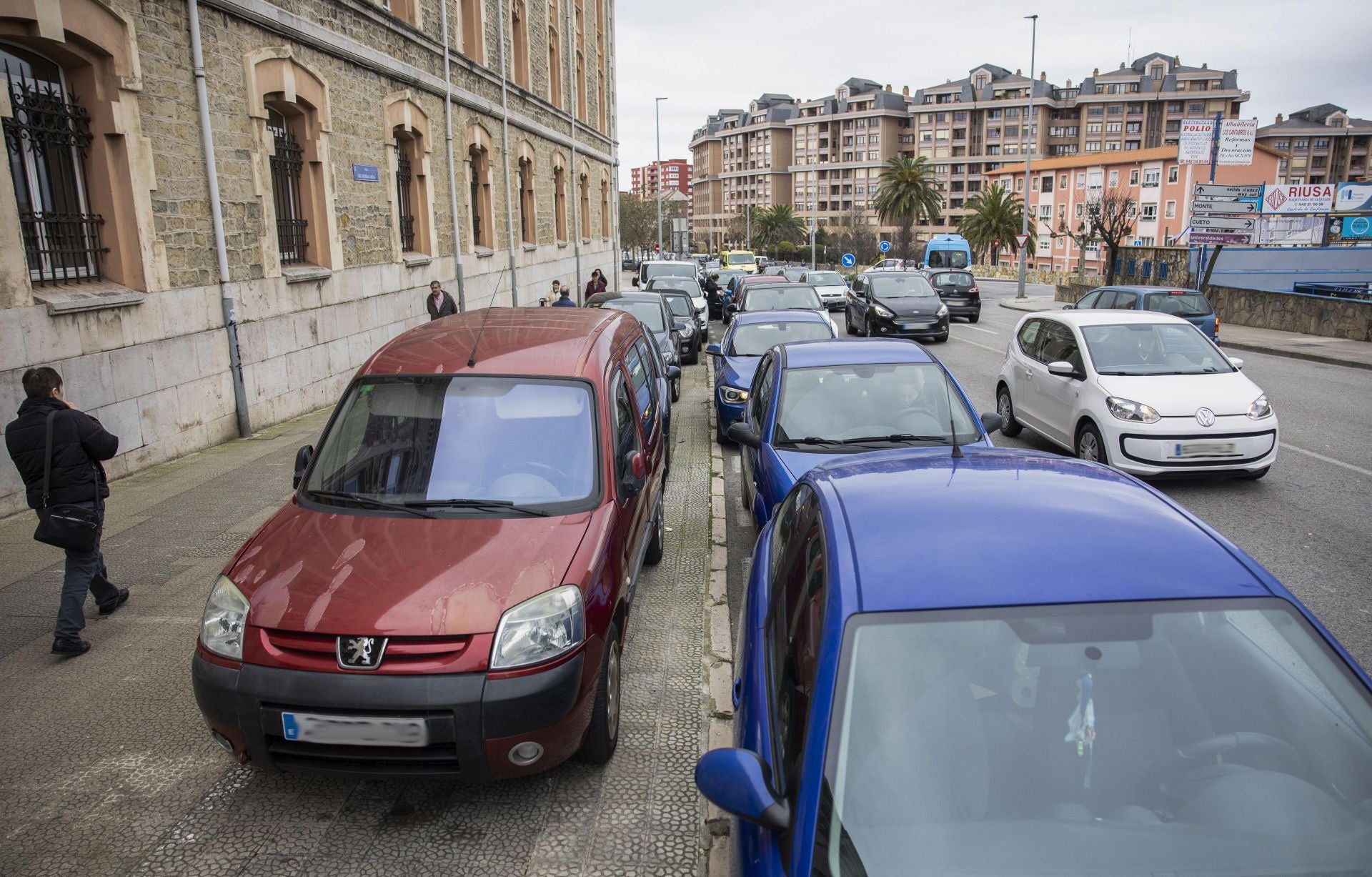 Varios coches aparcan sobre la acera junto a la entrada al colegio Salesianos, en General Dávila.