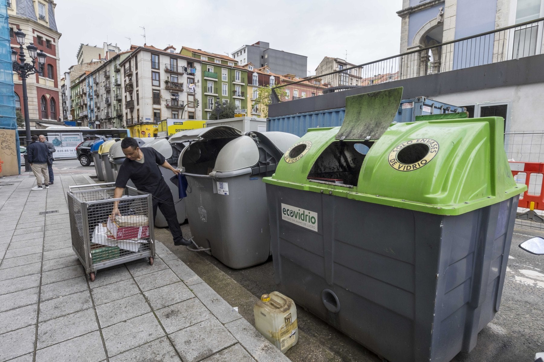 Un hombre hace uso de los contenedores localizados en el entorno del Mercado de Puertochico.