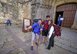 Tres peregrinos se hacen una fotografía en su llegada a la iglesia de San Vicente de la Barquera.