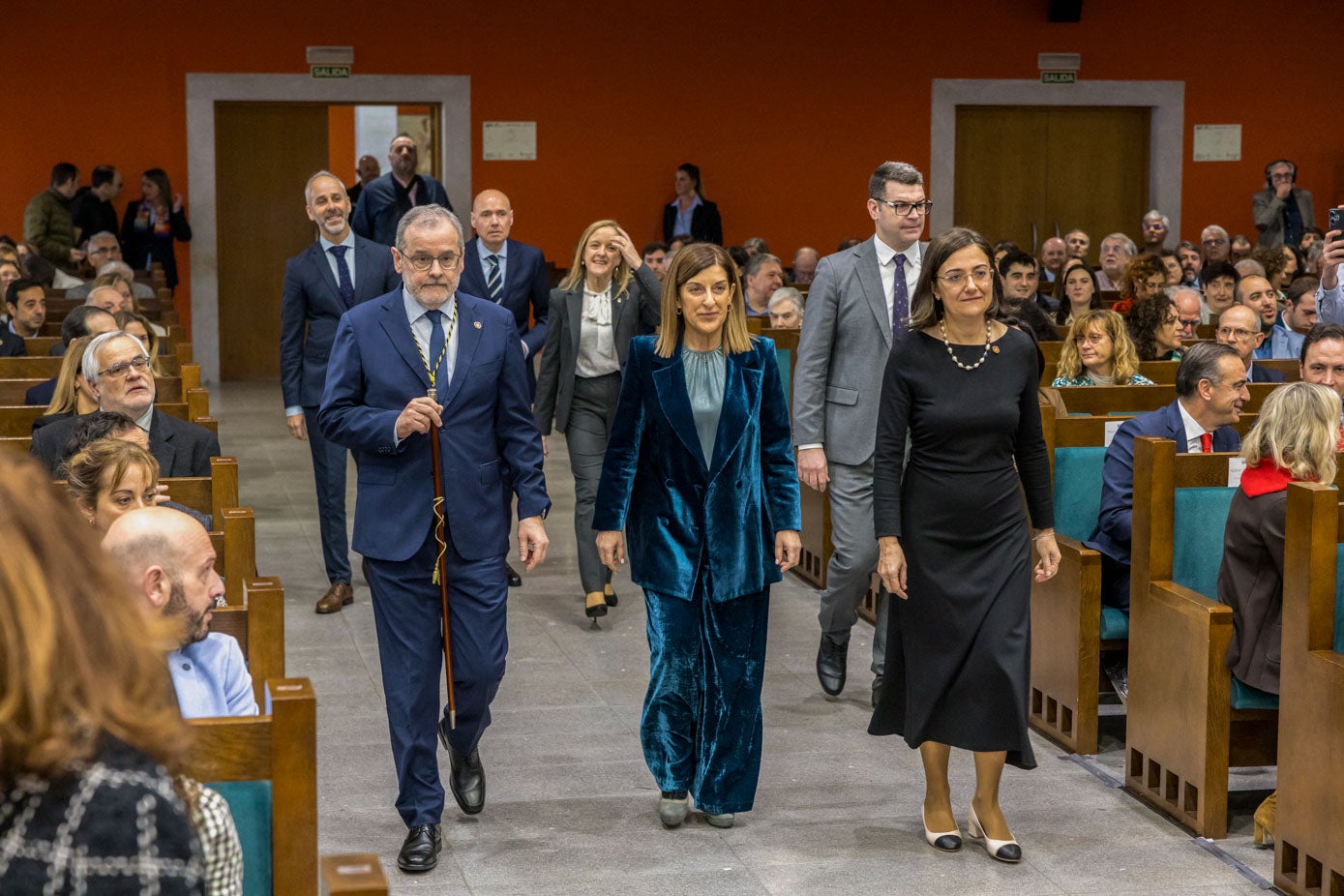 Conchi López entra en el Paraninfo de la UC, acompañada por la presidenta autonómica, María José Sáenz de Buruaga, y el rector saliente, Ángel Pazos. 