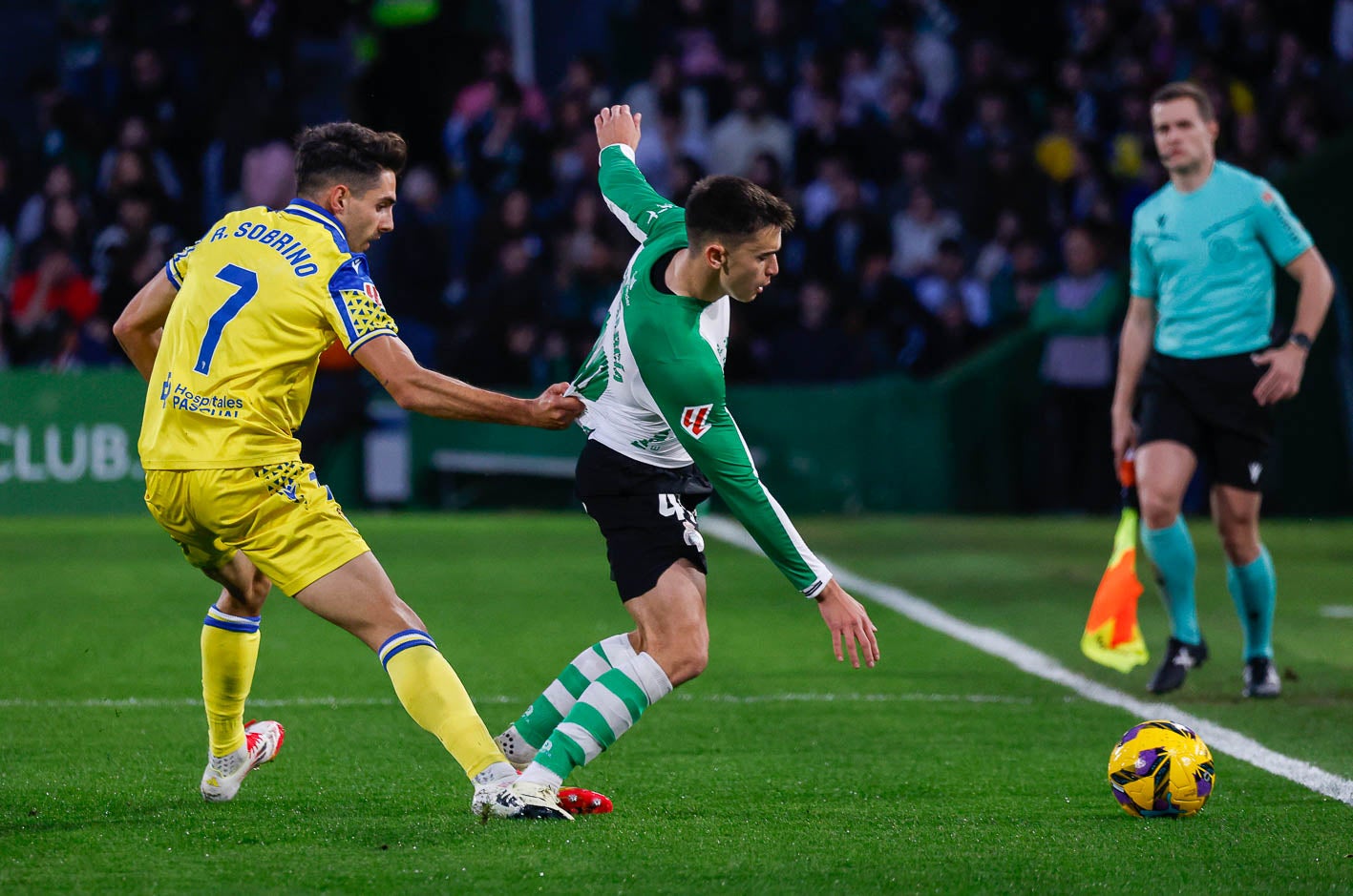 Sobrino, del Cádiz, agarra a Mario García para impedir que llegue al balón.