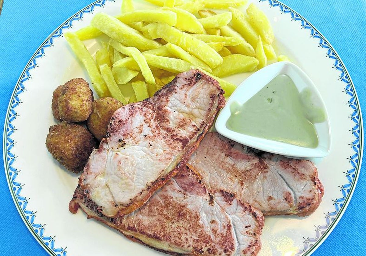 Plato combinado de lomo, queso fundido, croquetas y patatas fritas.