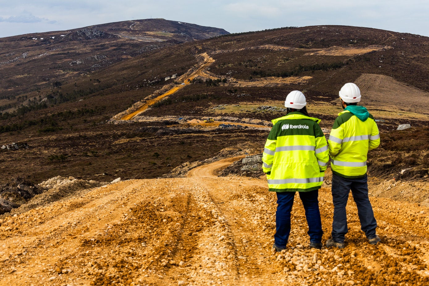 Dos ingenieros de Iberdrola, la promotora del proyecto, frente al camino que recorre toda la sierra, entre Luena y San Miguel de Aguayo.