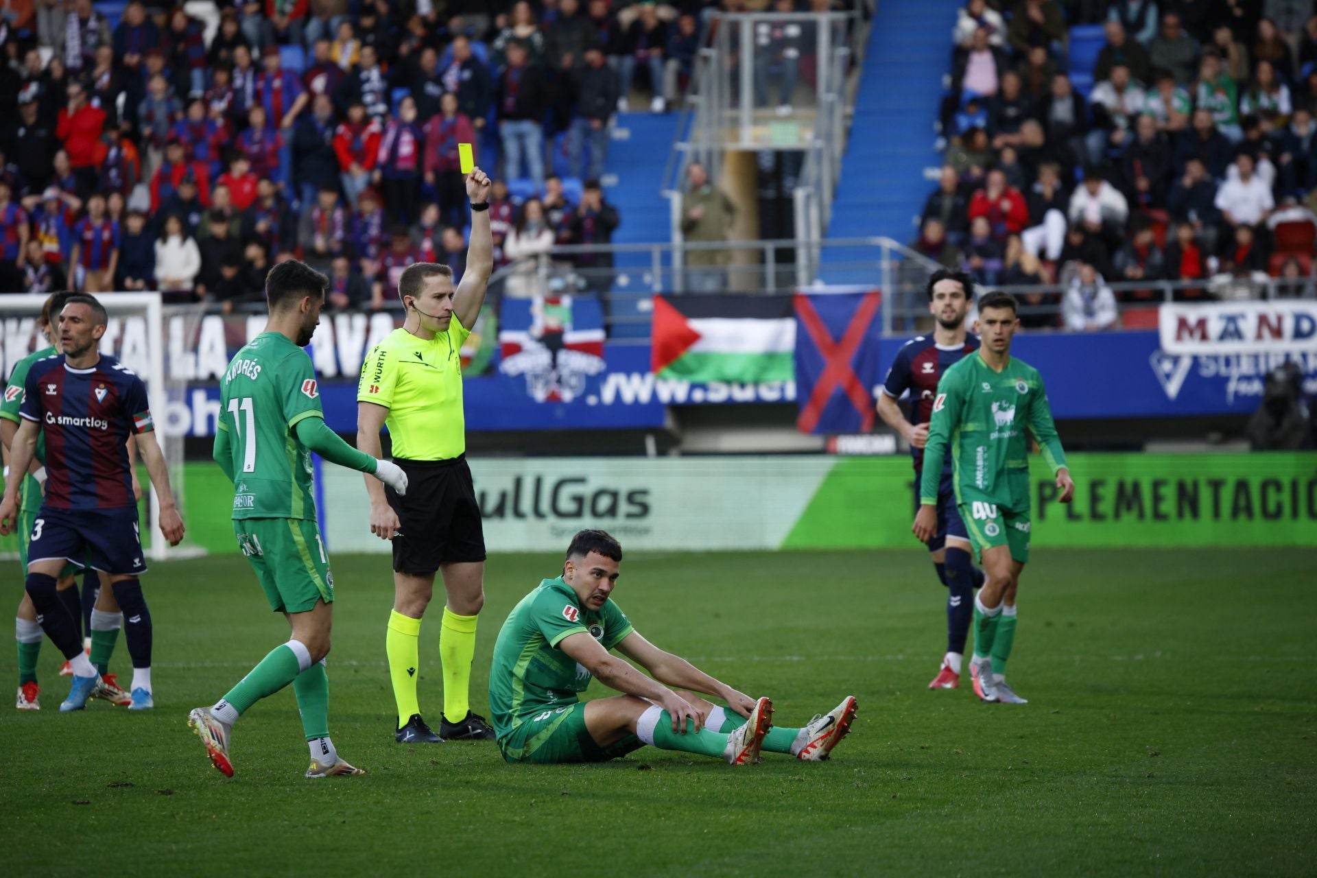 El árbitro muestra la amarilla a un jugador del Eibar por una falta sobre Arana.