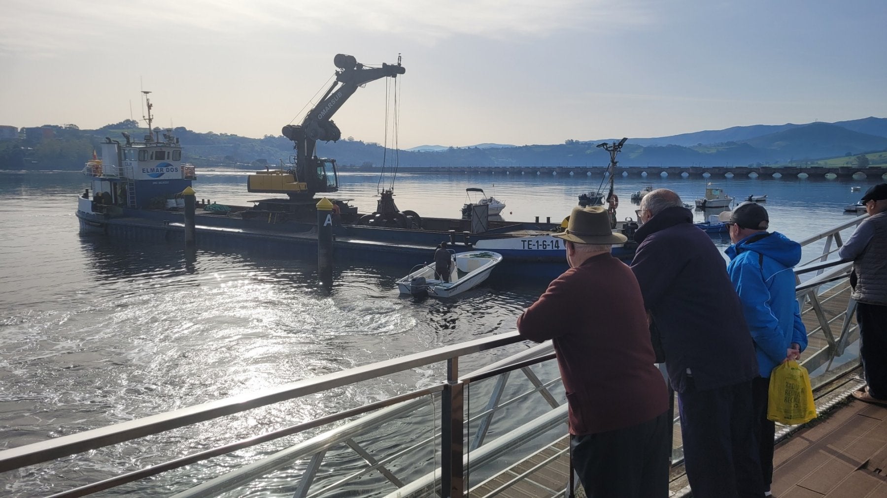 Vecinos observan los trabajos de dragado en el puerto de San Vicente en anteriores campañas.