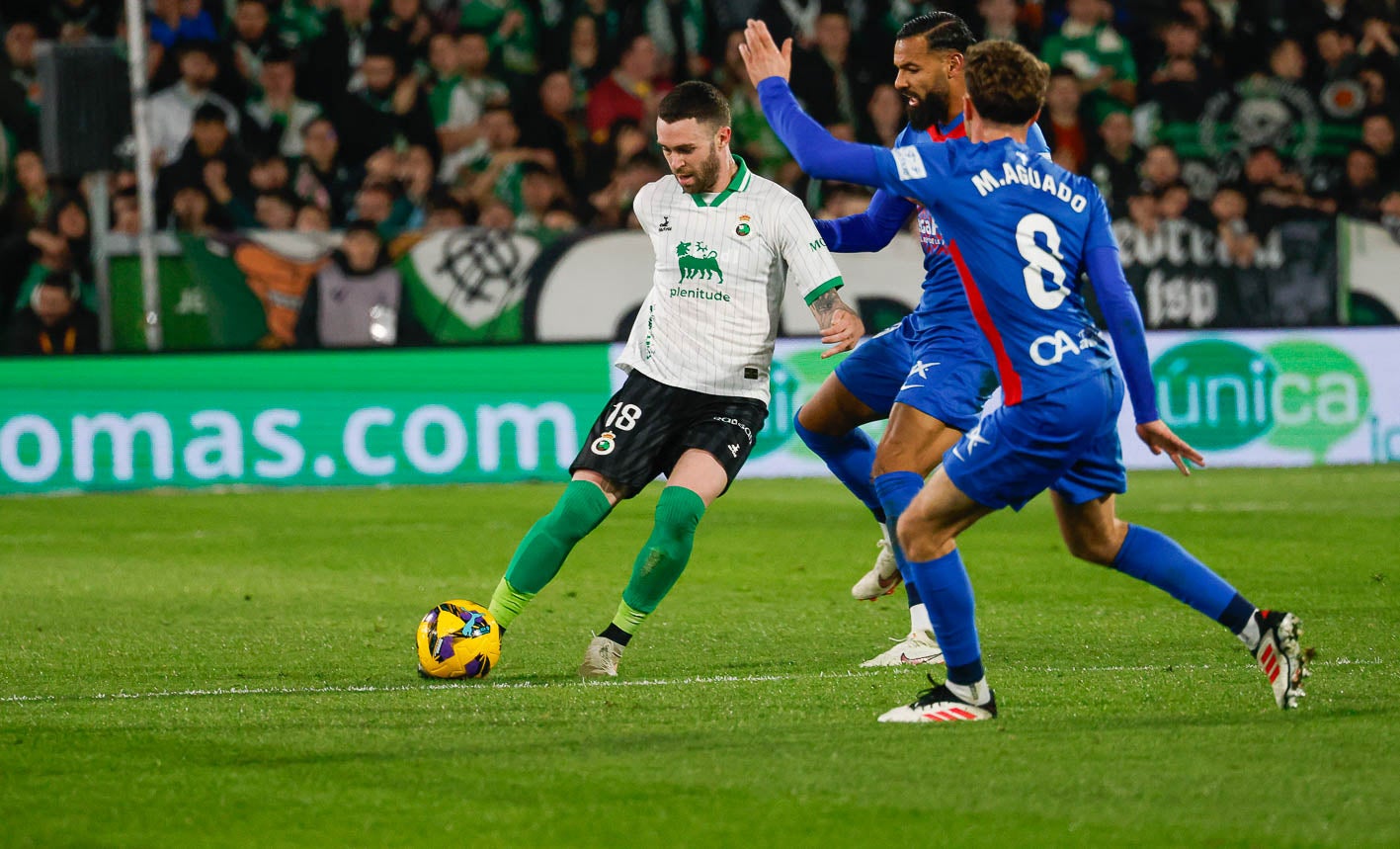 Manu Hernando protege la pelota ante dos jugadores del Elche 