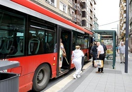 Vecinos se apean de un autobús del servicio de transporte urbano de Torrelavega, en la calle Julián Ceballos.