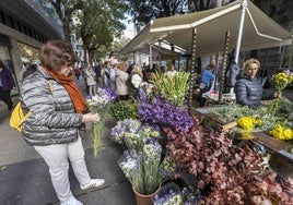 Una mujer elige un ramo en un puesto de flores en la calle Los Escalantes en Santander.