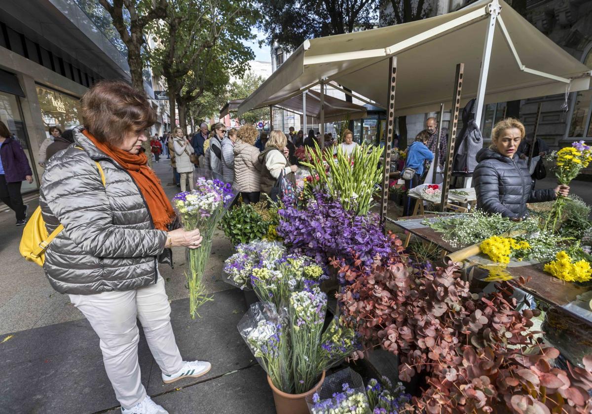 Una mujer elige un ramo en un puesto de flores en la calle Los Escalantes en Santander.