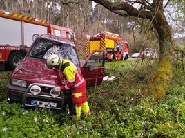 Un bombero revisa el coche volcado