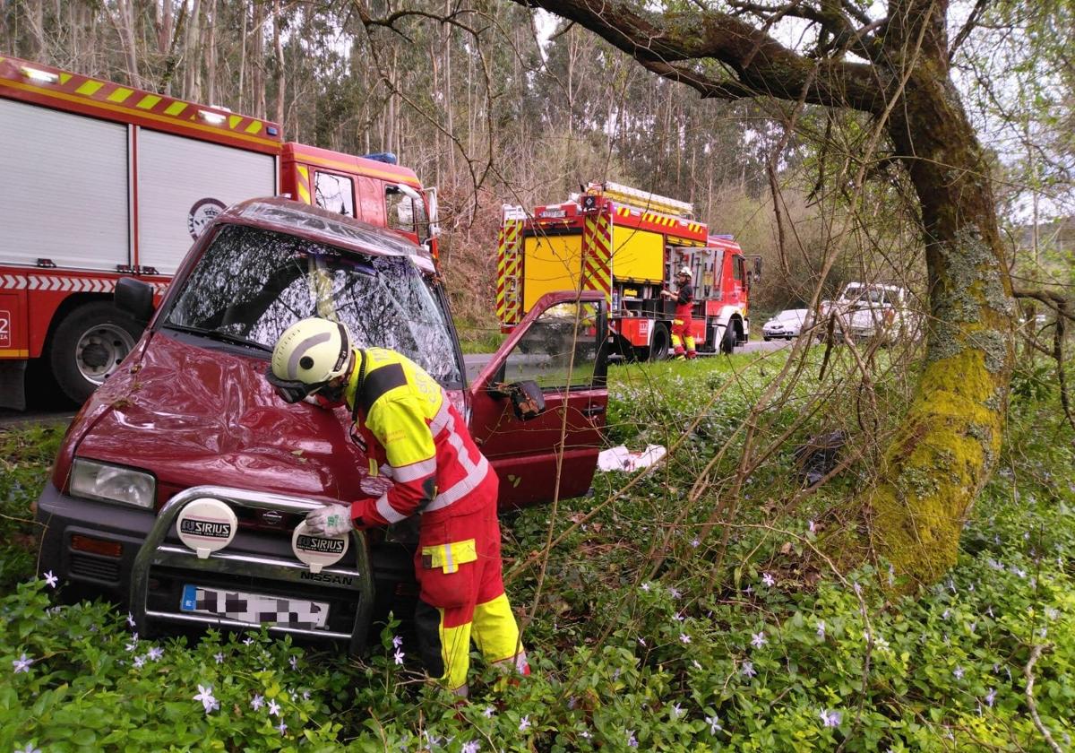 Un bombero revisa el coche volcado