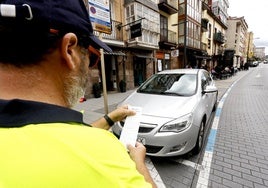 Un controlador procede a sancionar a un conductor, en la calle Julián Ceballos de Torrelavega.