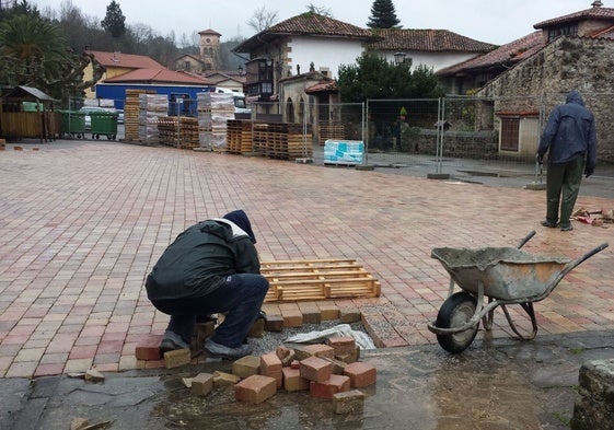 Dos obreros ejecutan la primera fase del empedrado de la plaza de Barcenaciones hace algunos años.