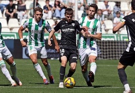 Aleix Febas, del Elche, con el balón, ante dos rivales del Córdoba.