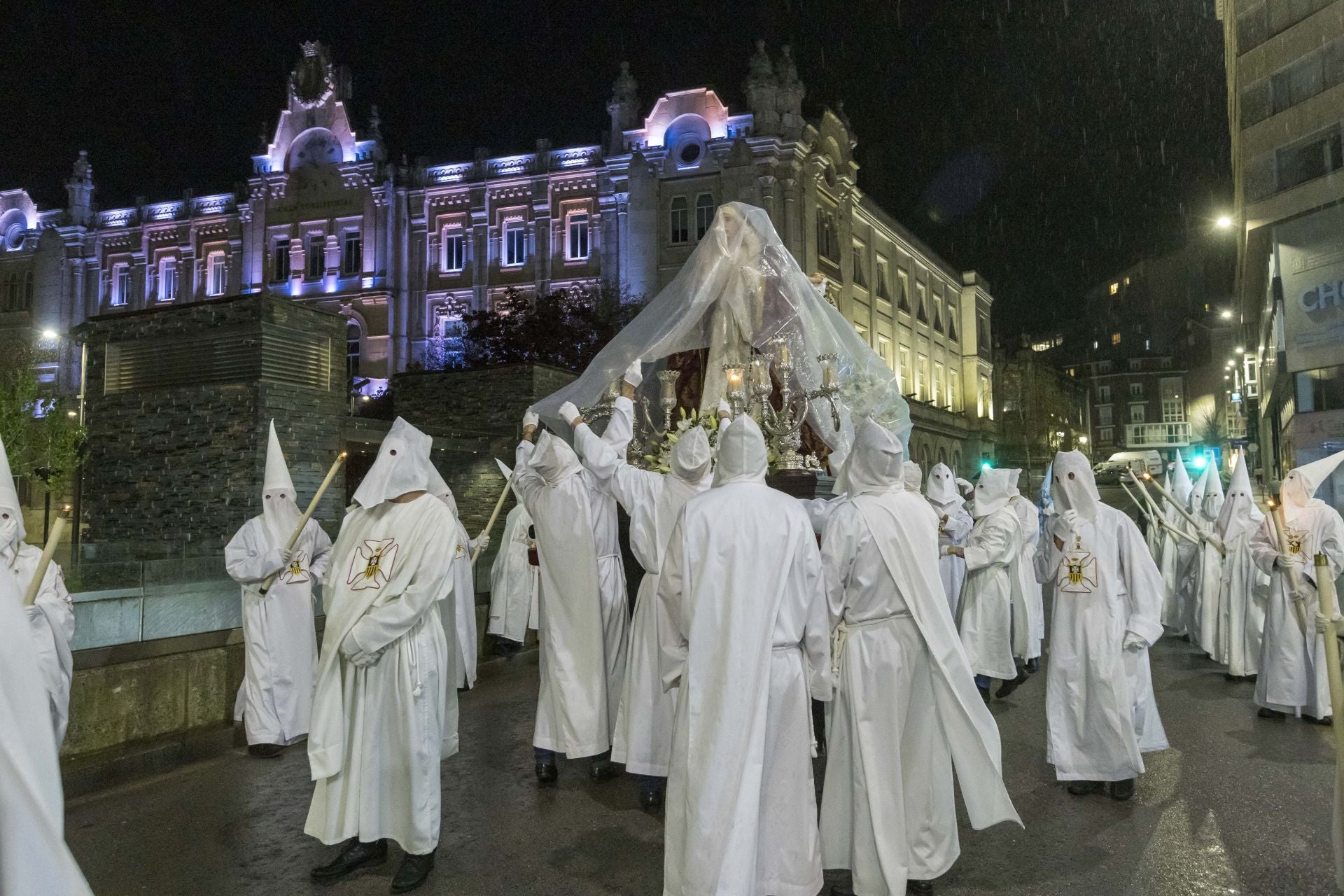 La lluvia obligó a cubrir con plásticos la imagen que procesionaba.